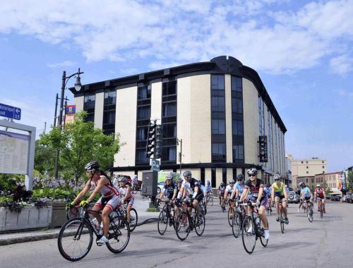 a group of people riding bikes down a street at Hotel Chicoutimi in Saguenay