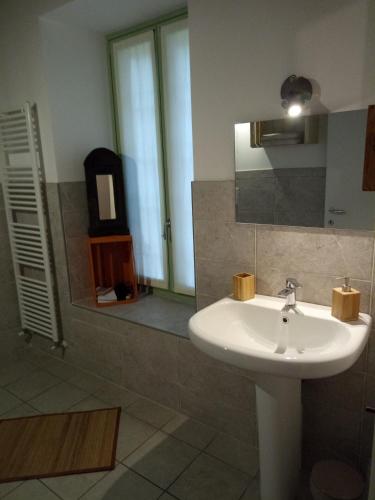 a bathroom with a white sink and a mirror at Casa Artisti del Sole in Paratico