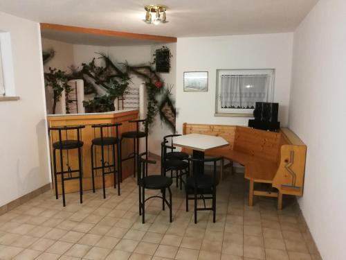 a room with a table and chairs and a bar at Landhaus Breitenberg in Bad Hofgastein