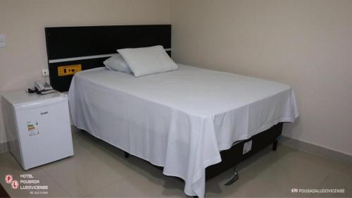 1 dormitorio con 1 cama blanca con manta blanca en Hotel Pousada Ludovicense, en São Luís