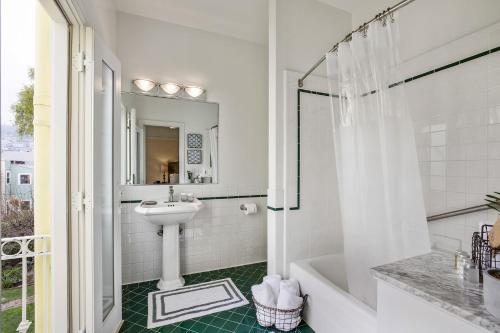y baño blanco con lavabo y ducha. en Parker Guest House en San Francisco
