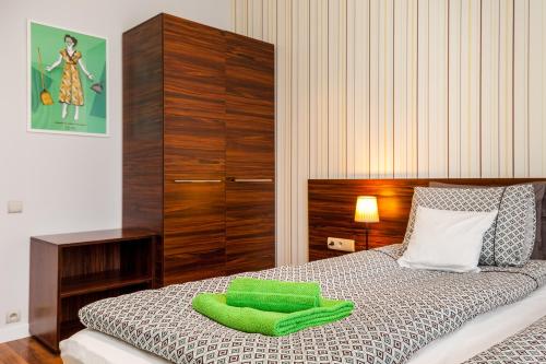 a bedroom with a bed with green pillows on it at Apartamenty Black&White in Gdynia