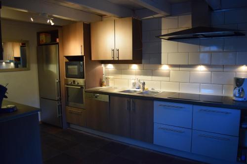 a kitchen with a sink and a stove top oven at La Villa Blanche in Houffalize