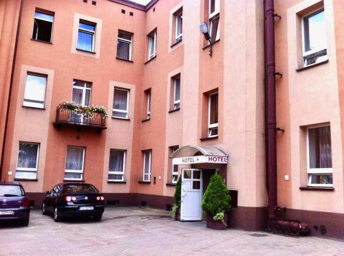 a large building with a car parked in front of it at Hotel Haga in Częstochowa