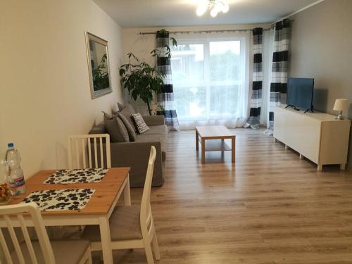 uma sala de estar com uma mesa e um sofá em Szafarnia/Sw Barbary 12 em Gdansk