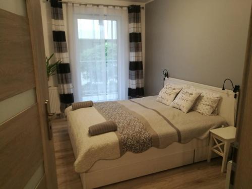 um quarto com uma cama grande e uma janela em Szafarnia/Sw Barbary 12 em Gdansk