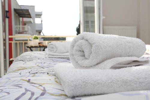 a pile of towels sitting on top of a bed at Pantheon City Center Studio in Thessaloniki