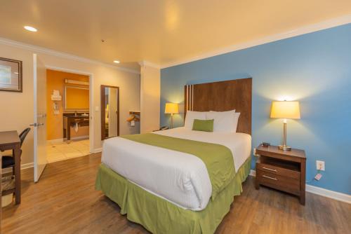 a bedroom with a large bed with a desk and a desk at Ocean Pacific Lodge in Santa Cruz