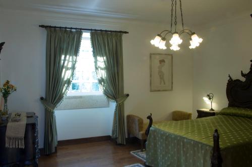 a bedroom with a green bed and a window at Casa De Santa Comba in Cabeceiras de Basto