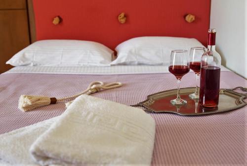 a table with two glasses of wine on a bed at Angelina's Home in Palaiá Fókaia