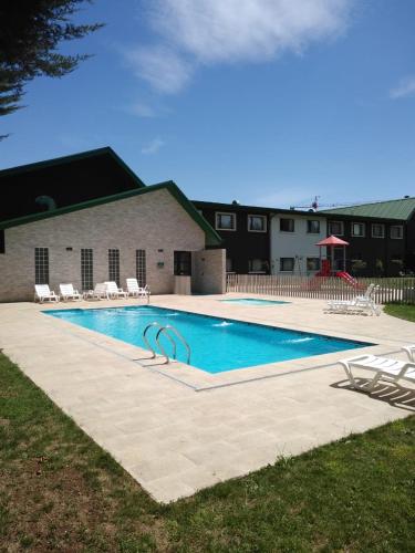 a large swimming pool with chairs and a building at Hotel Diego de Almagro Osorno in Osorno