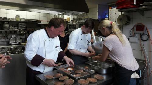 a group of people in a kitchen preparing food at Neumanns Waldschänke in Soltau