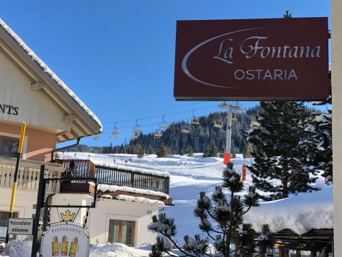 um sinal para um hotel numa estância de esqui em Ostaria La Fontana em Corvara in Badia