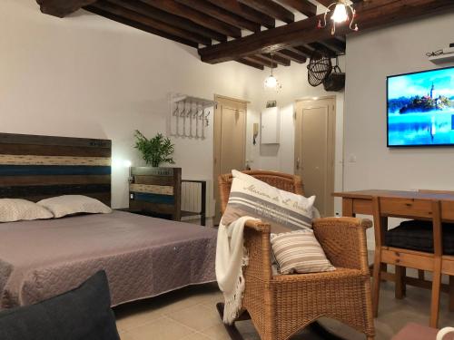una camera da letto con un letto, un tavolo e una TV di L'authentique a Honfleur