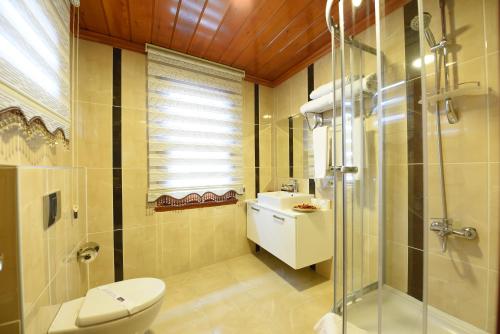 a bathroom with a shower and a toilet and a sink at Elyka Hotel in Istanbul