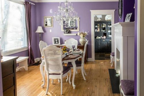 a dining room with purple walls and a table and chairs at Charles Street Vacation Home in Lethbridge