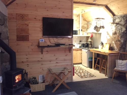 a kitchen with a stove and a television on a wall at The Barn | Aberlour in Aberlour