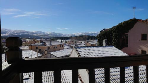 a view from a balcony of a city with snow covered roofs at Artesano I y III in Navarredonda de Gredos