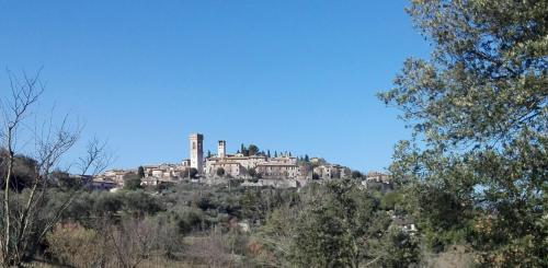 a castle on top of a hill with trees at B&B Al Borgo in Corciano