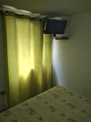 a bedroom with a bed and a curtain at Hotel Angamos in Santiago