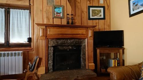 a living room with a fireplace and a television at Artesano I y III in Navarredonda de Gredos