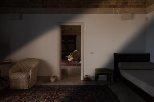 a bedroom with a bed and a chair and a doorway at Masseria Fontana di Vite in Matera