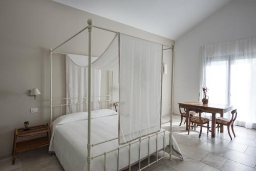 a bedroom with a canopy bed and a table at Masseria Fontana di Vite in Matera