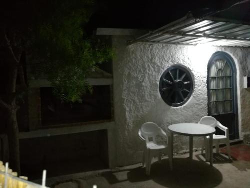 a table and chairs on a patio at night at Casa en Alquiler in Piriápolis