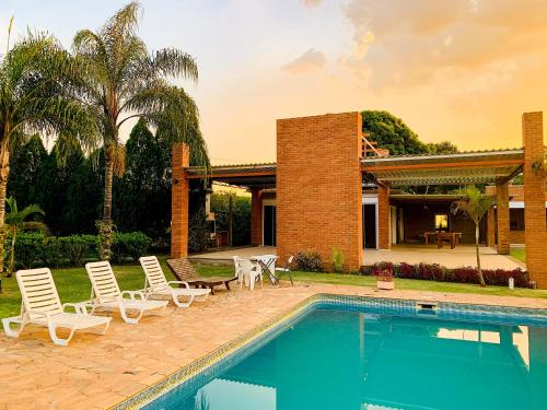 a villa with a swimming pool and a house at Parque Hotel Holambra in Holambra