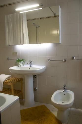 a bathroom with a sink and a toilet and a mirror at Casa Araucana - WelcHome in Cannobio