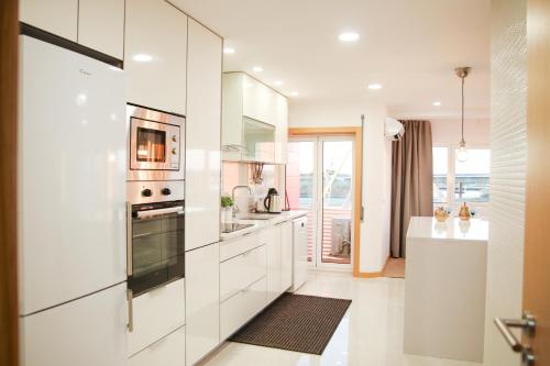 a kitchen with white cabinets and a stove top oven at Aveiro Rossio View II in Aveiro