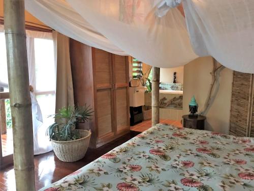 a bedroom with a bed with a floral bedspread at Naveria Heights Lodge in Savusavu