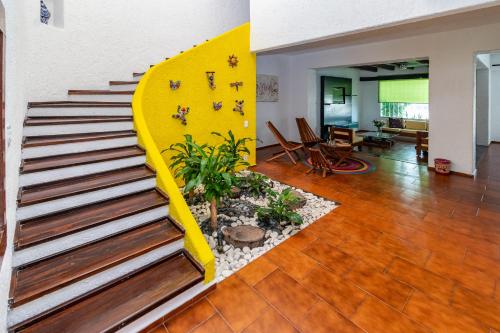 a staircase in a living room with a yellow wall at Grandiosa casa céntrica a minutos de la playa in Cancún