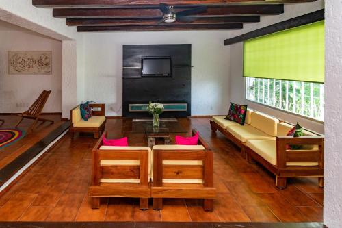 a living room with a couch and a tv at Grandiosa casa céntrica a minutos de la playa in Cancún