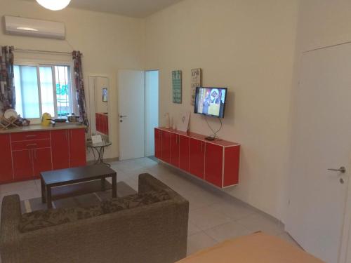 a living room with red cabinets and a tv on the wall at Amir's Apartments in Tel Aviv