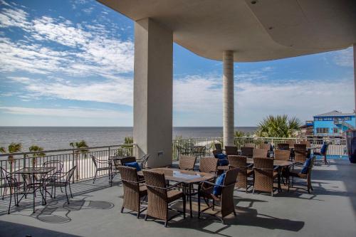 a patio with tables and chairs and a view of the ocean at South Beach Biloxi Hotel & Suites in Biloxi