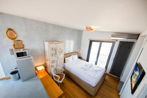 Dormitorio pequeño con cama y nevera en Topfloor stylish apartment with Acropolis view! en Athens