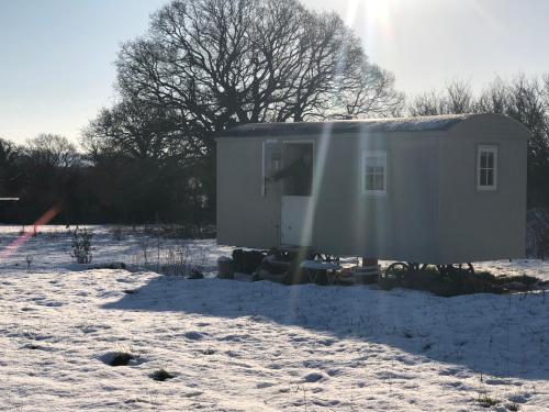 a large white truck parked in a snow covered yard at Romantic secluded Shepherd Hut Hares Rest in Southwick
