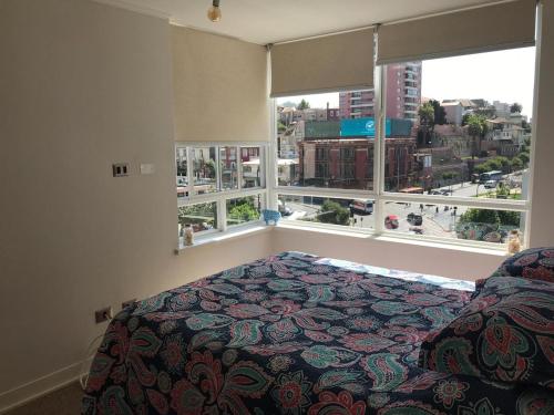 1 dormitorio con cama y ventana grande en Departamento perfecta ubicación Viña del Mar, en Viña del Mar