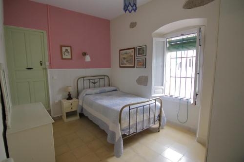 a bedroom with a bed and a window at Apartamentos Altozano in Trujillo