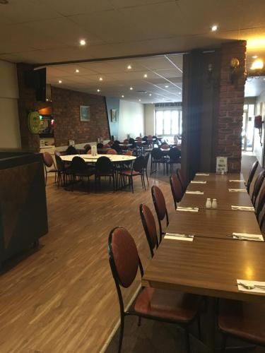 a restaurant with wooden tables and chairs and a room with tables at Yarram Commecial Hotel Motel in Yarram