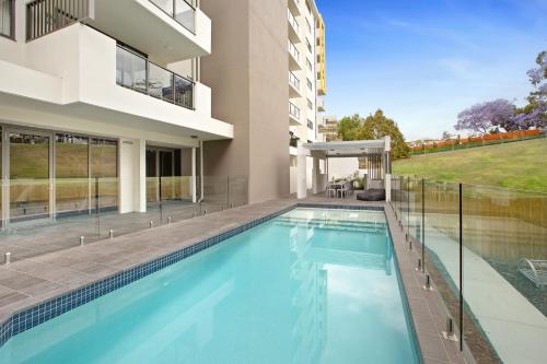 a large swimming pool in front of a large building at Quest Kelvin Grove in Brisbane