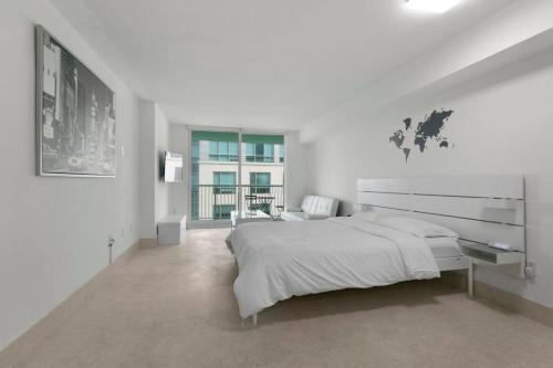 Un dormitorio blanco con una cama grande y una ventana. en Centric Modern, Stylish Brickell / Miami + FREE Parking, en Miami