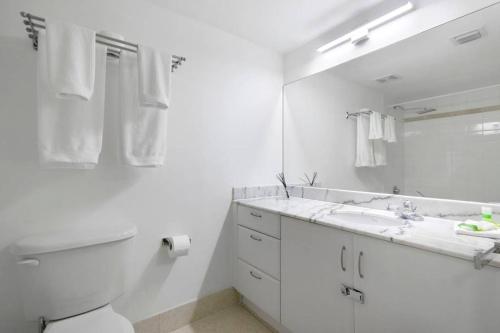 Un baño blanco con inodoro y lavabo. en Centric Modern, Stylish Brickell / Miami + FREE Parking, en Miami