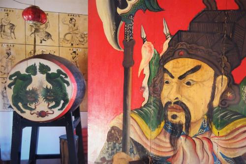 a painting of a man with a spear and a painting of a man with at Mayo Resort in Umeanyar
