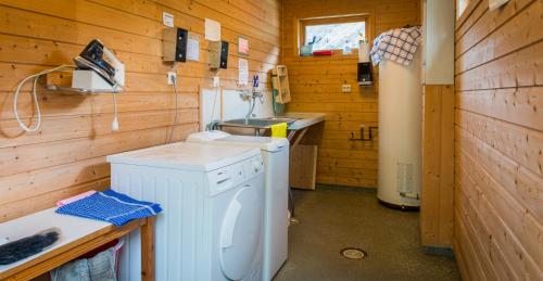 a laundry room with a washer and a sink at Nesset Fjordcamping in Olden