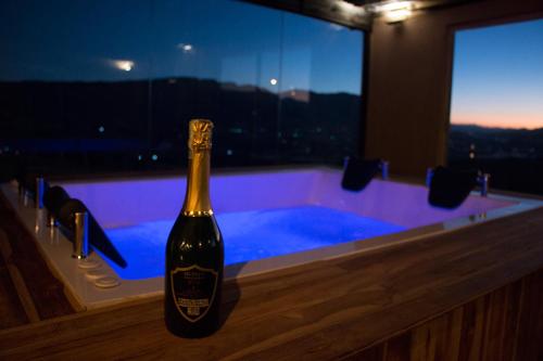 Una botella de vino sentada en una barra frente a una bañera en Hotel Ika Mirador Suesca, en Suesca