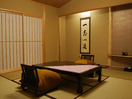 a room with a table and chairs in a room at Ryokan Shinsen in Takachiho