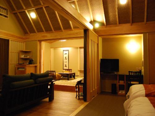 a bedroom with a bed and a living room with a couch at Ryokan Shinsen in Takachiho