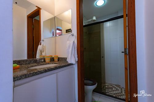 W łazience znajduje się umywalka, prysznic i lustro. w obiekcie Apartamento Villa da Praia Residence w mieście Arraial do Cabo